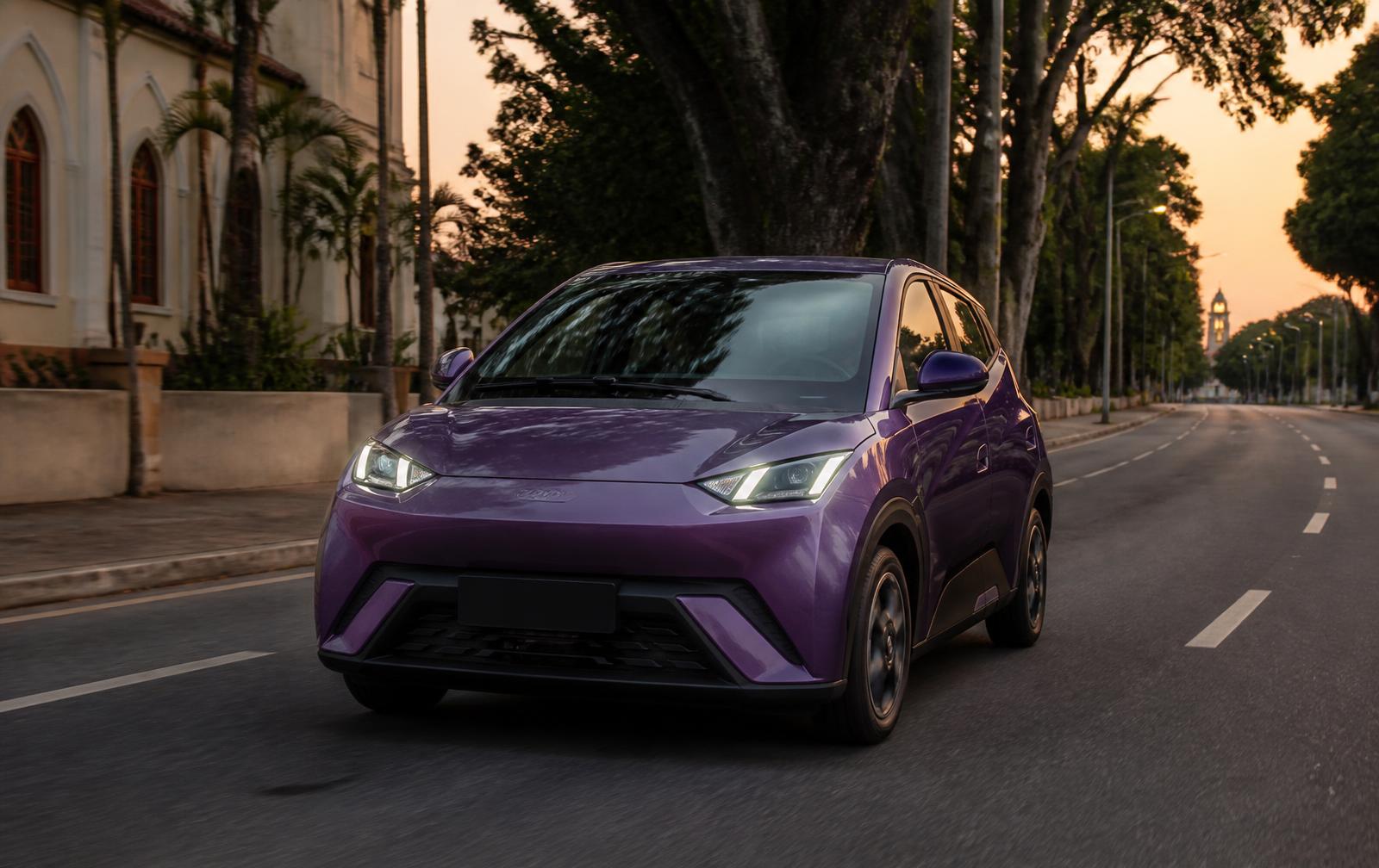 Carro roxo da Zipe circulando por uma avenida da cidade ao anoitecer
